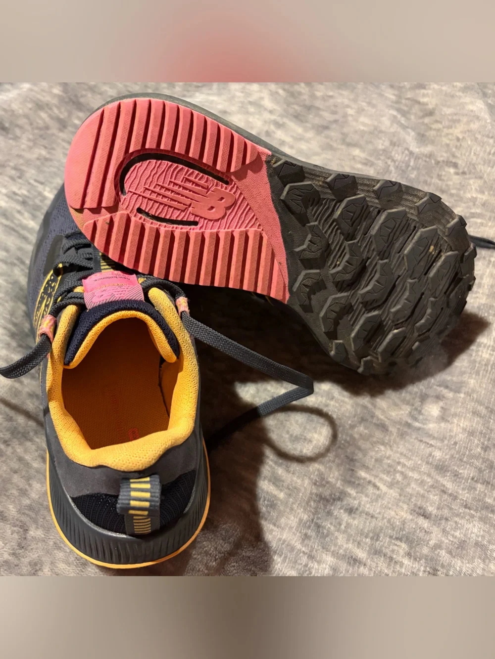 New Balance navy athletic sneakers with yellow and pink accents